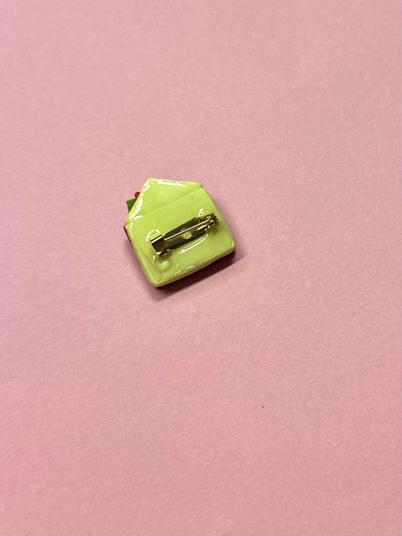 Broche de sobre amarillo y flores rojas