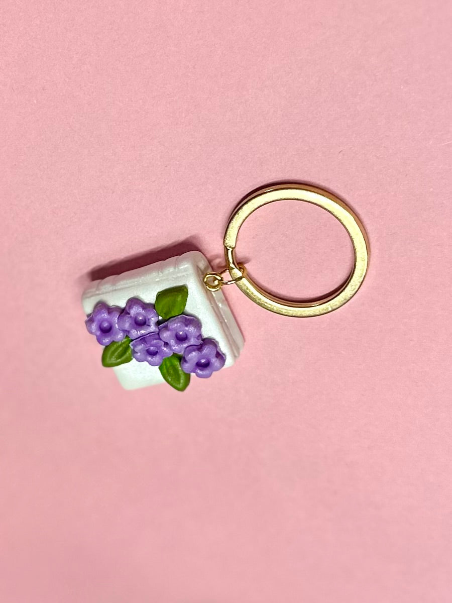 Llavero de libro blanco y flores lilas
