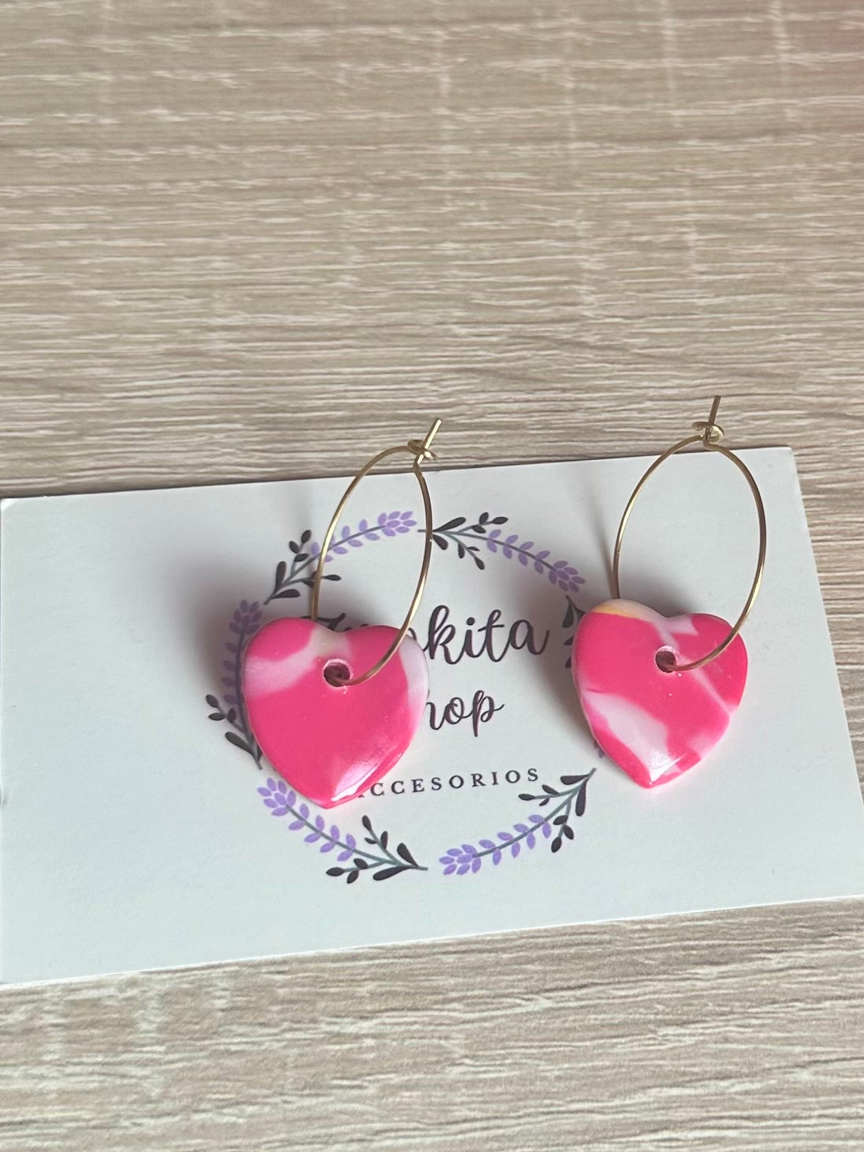 Aretes de corazón estampado rosa.