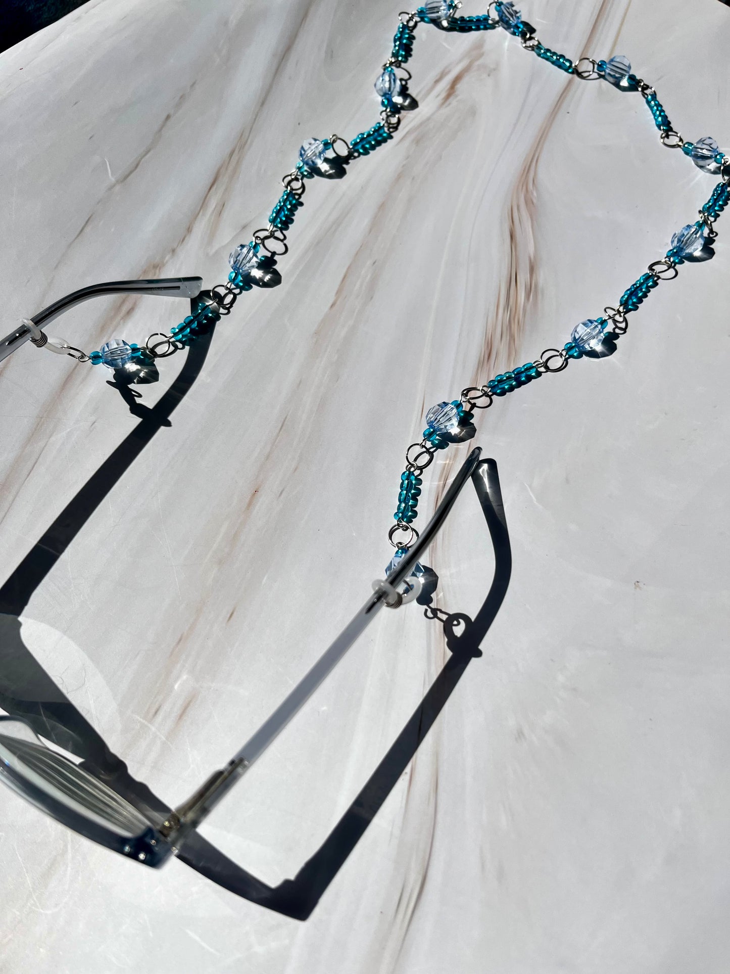 Cadena para gafas con cuentas azules y plateadas.