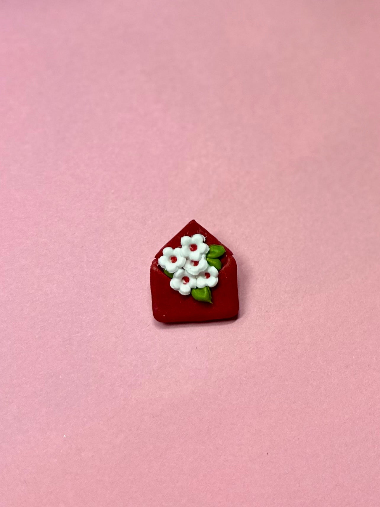 Broche de sobre rojo y flores blancas