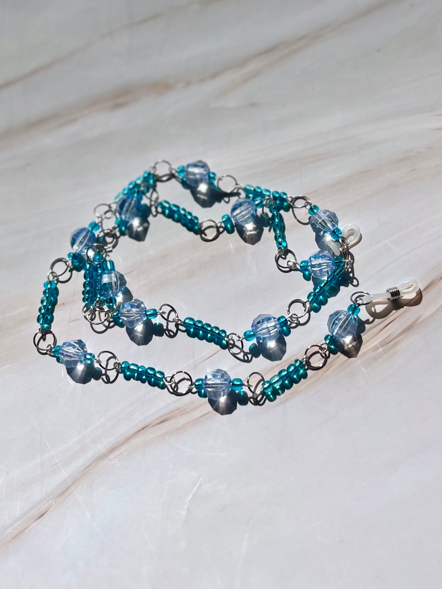 Cadena para gafas con cuentas azules y plateadas.