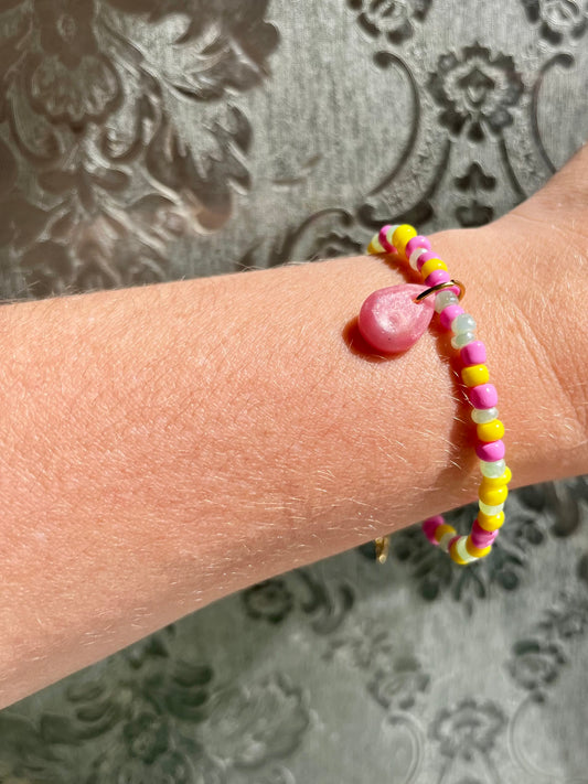 Pulsera con piedras verdes, rosas y amarillas.
