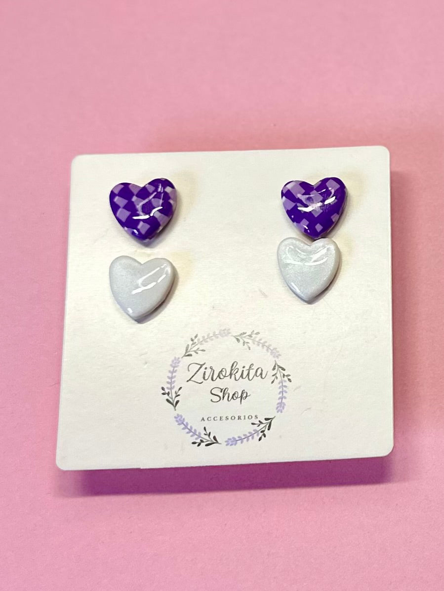 Pack de dos pendientes de corazón blanco y estampado lila.