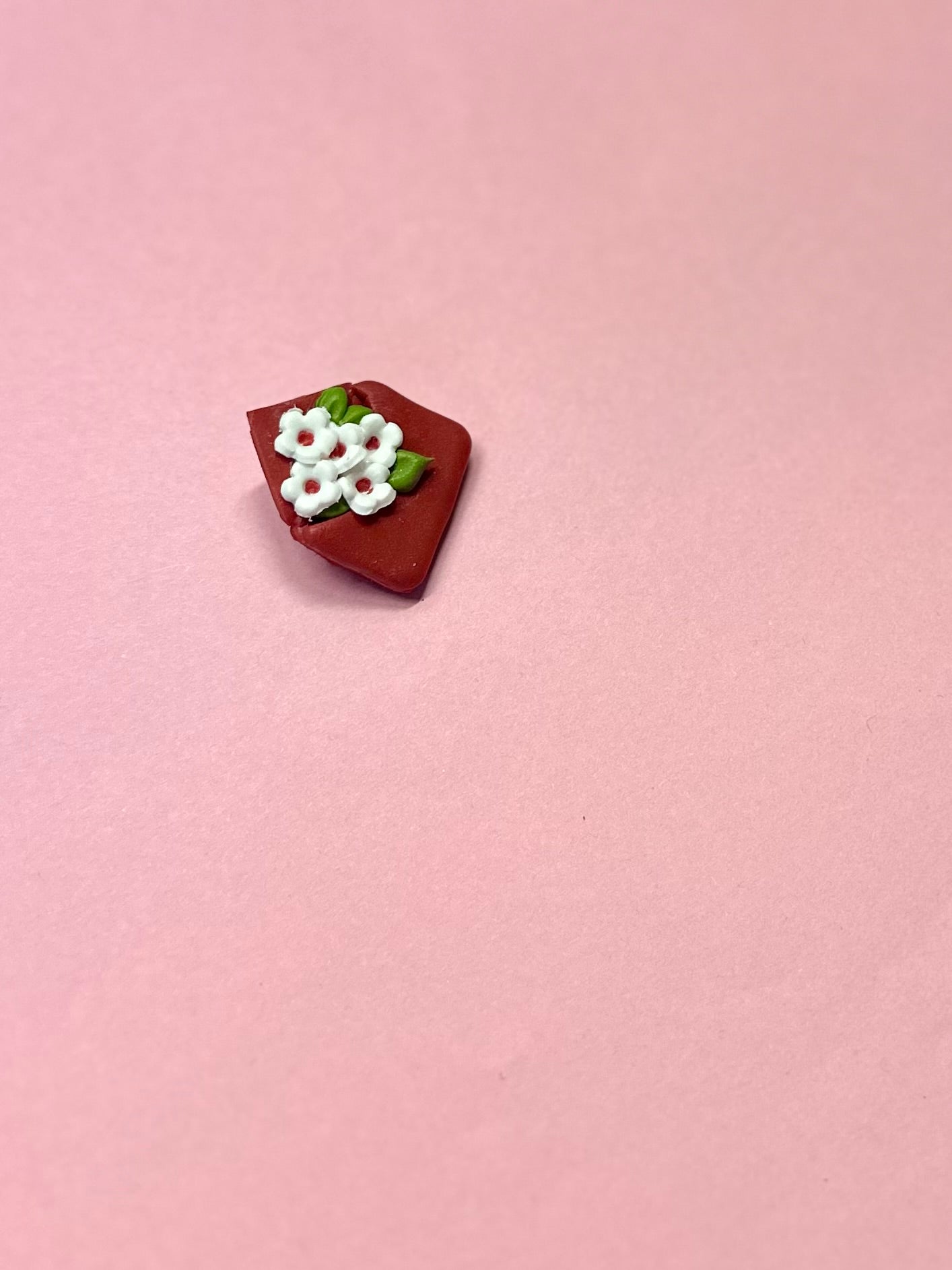 Broche de sobre rojo y flores blancas