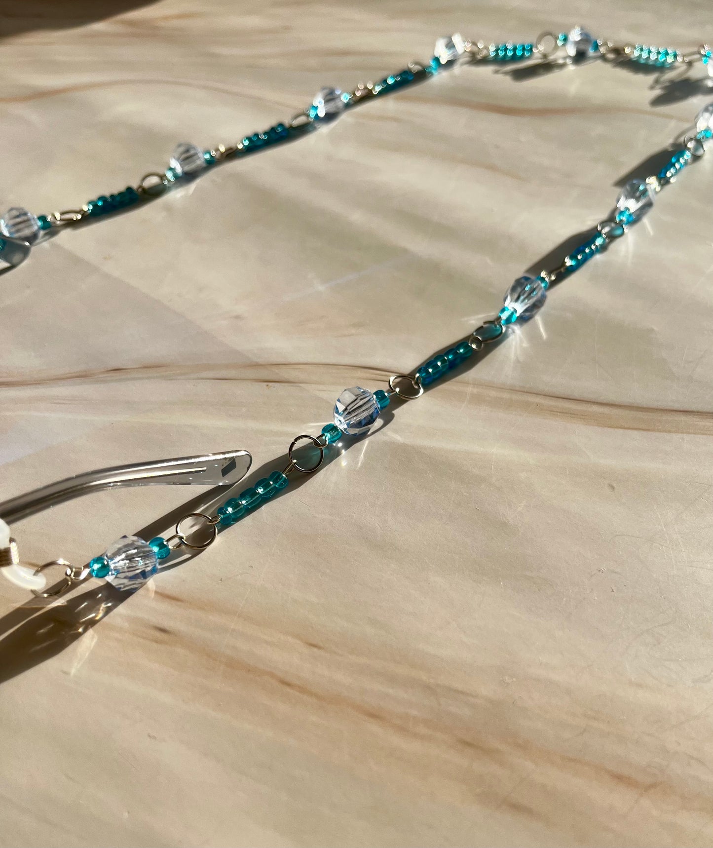 Cadena para gafas con cuentas azules y plateadas.
