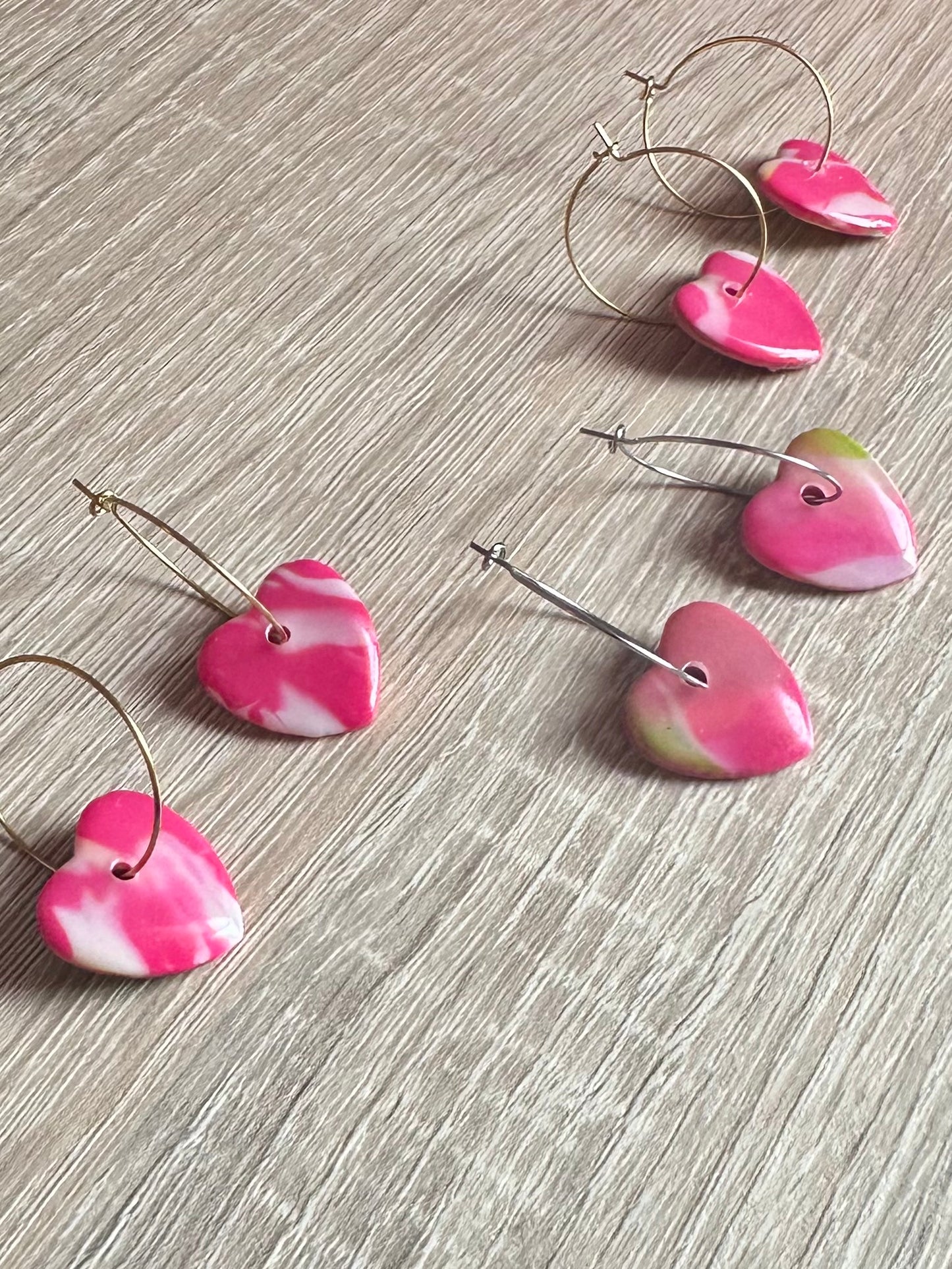 Aretes de corazón estampado rosa.