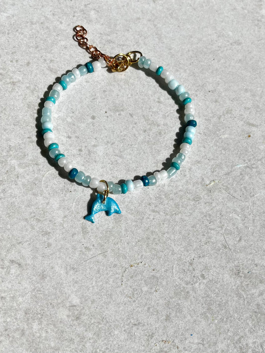 Pulsera de delfín con abalorios en blanco y azul.