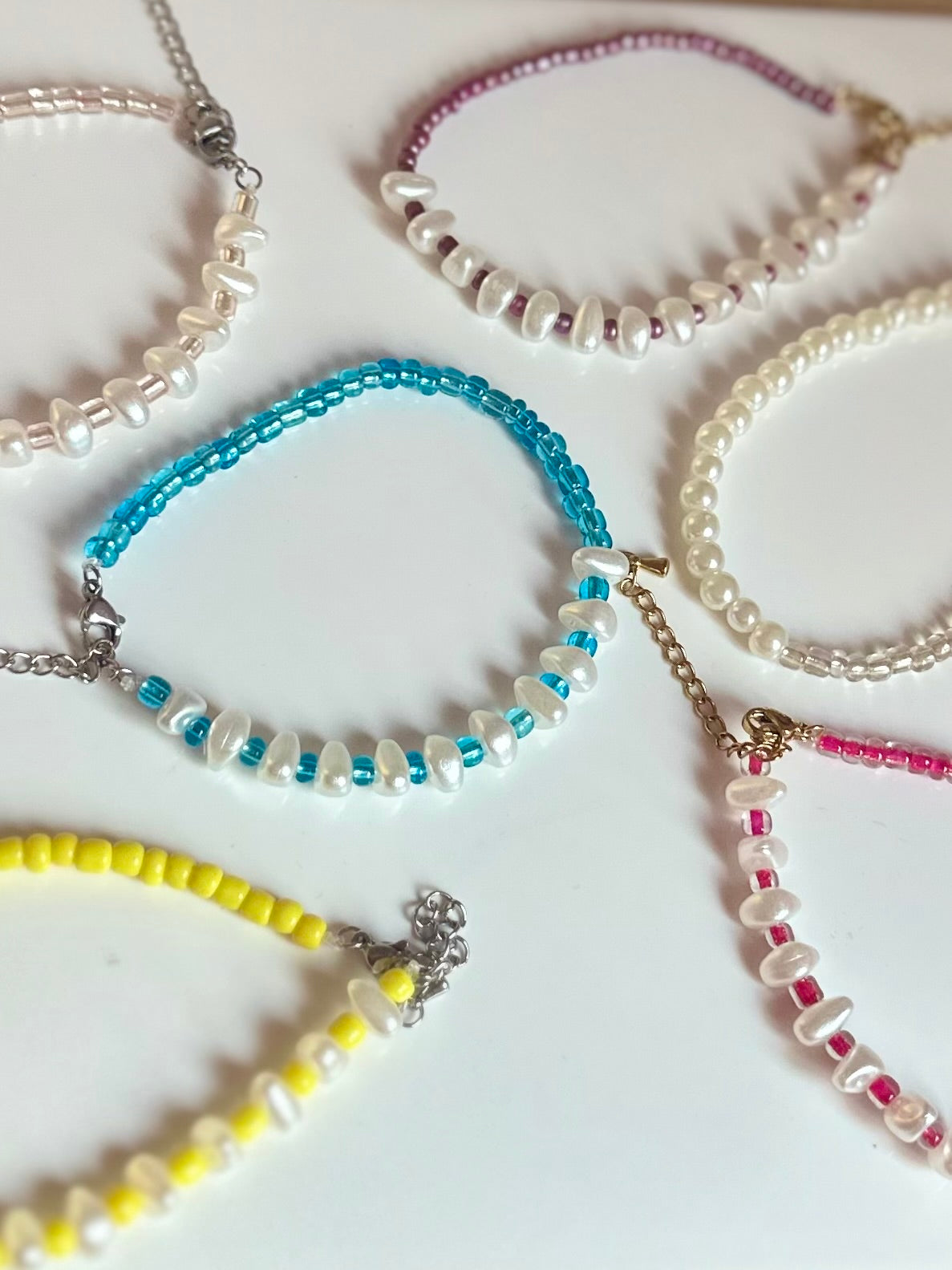 Pulseras de piedras blancas perladas y abalorios.