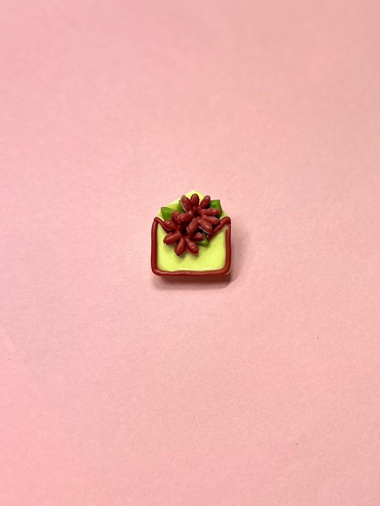 Broche de sobre amarillo y flores rojas