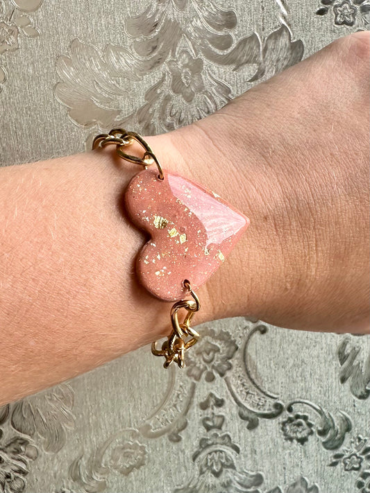 Pulsera de accesorios dorado y figura de corazón rosa y dorado de arcilla polimerica.