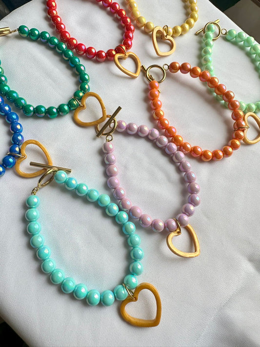 Pulsera de abalorios de colores y accesorios blancos.