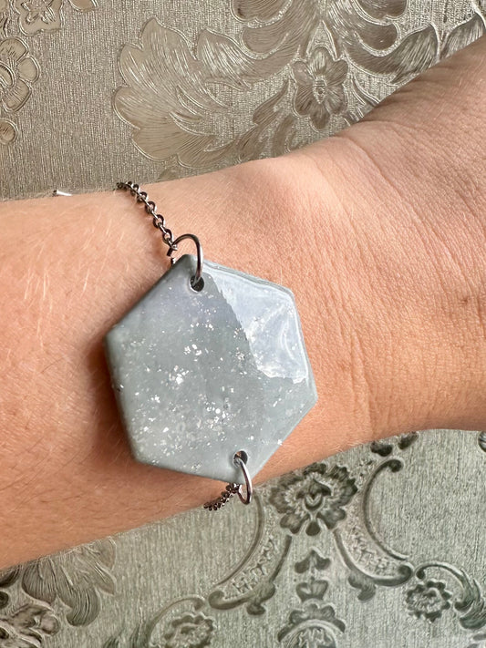 Pulsera de accesorios plateados y figura geométrica de estampado gris de arcilla polimerica