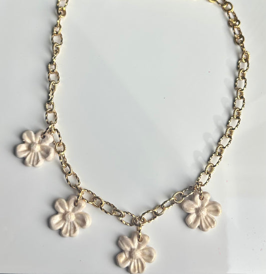 Collar de flores marfil con cadena dorada.