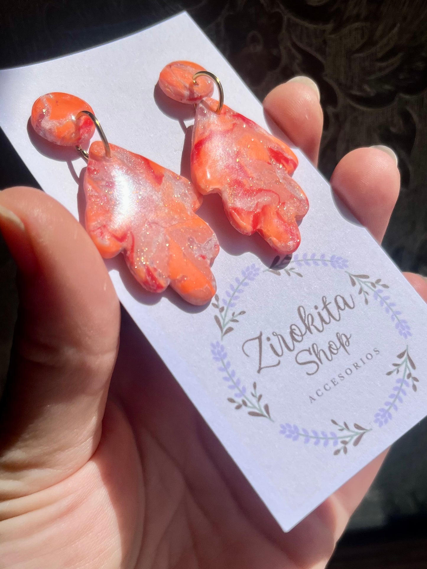 Pendientes de estampado en colores cálidos con accesorios en dorado.