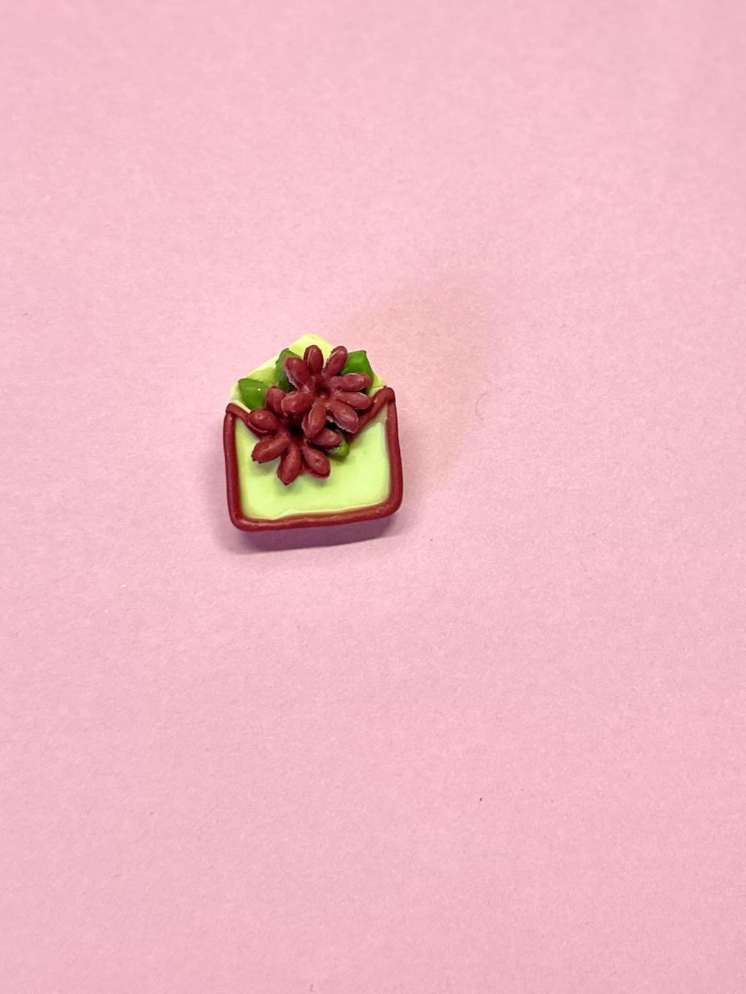Broche de sobre amarillo y flores rojas