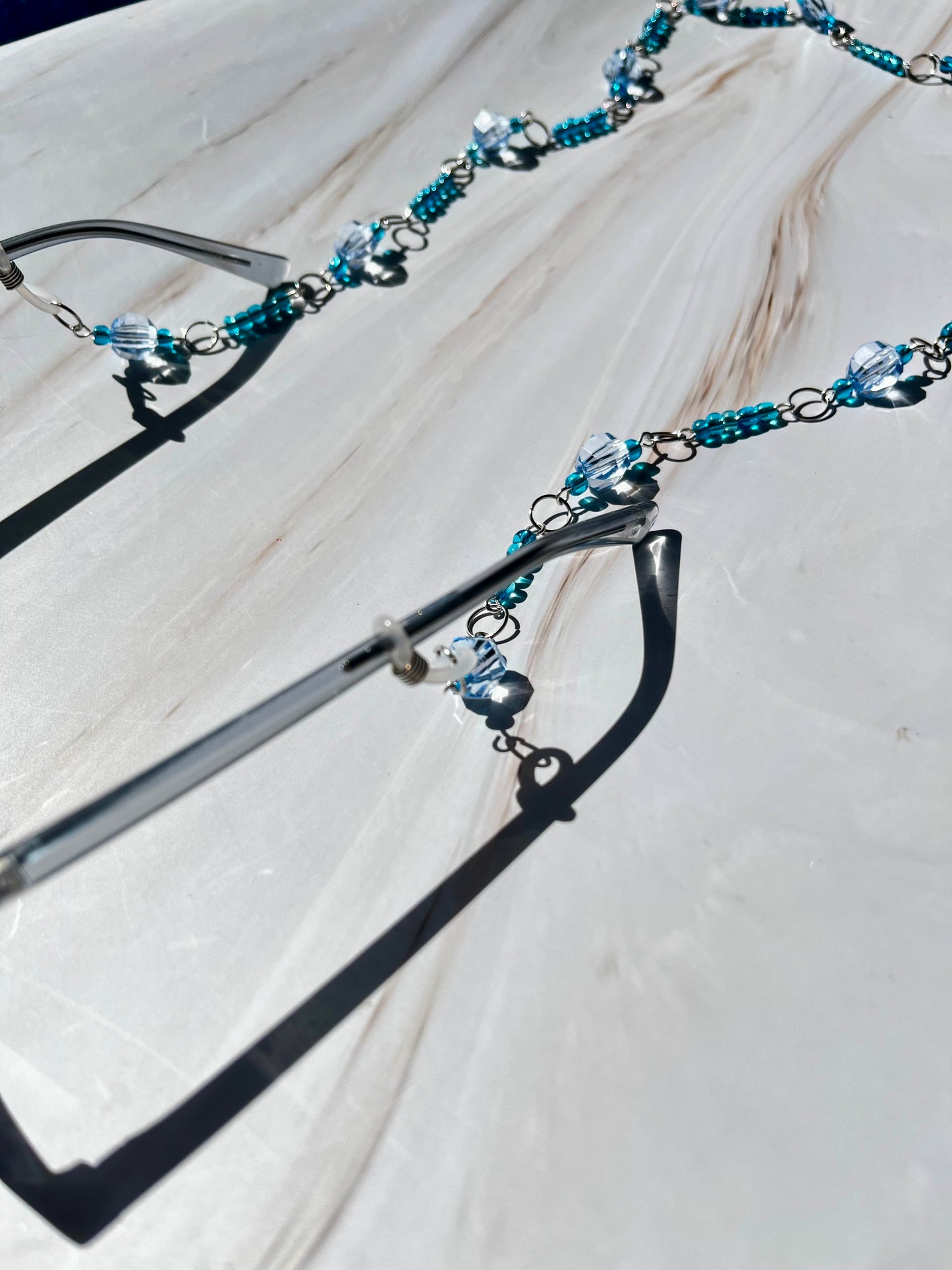 Cadena para gafas con cuentas azules y plateadas.