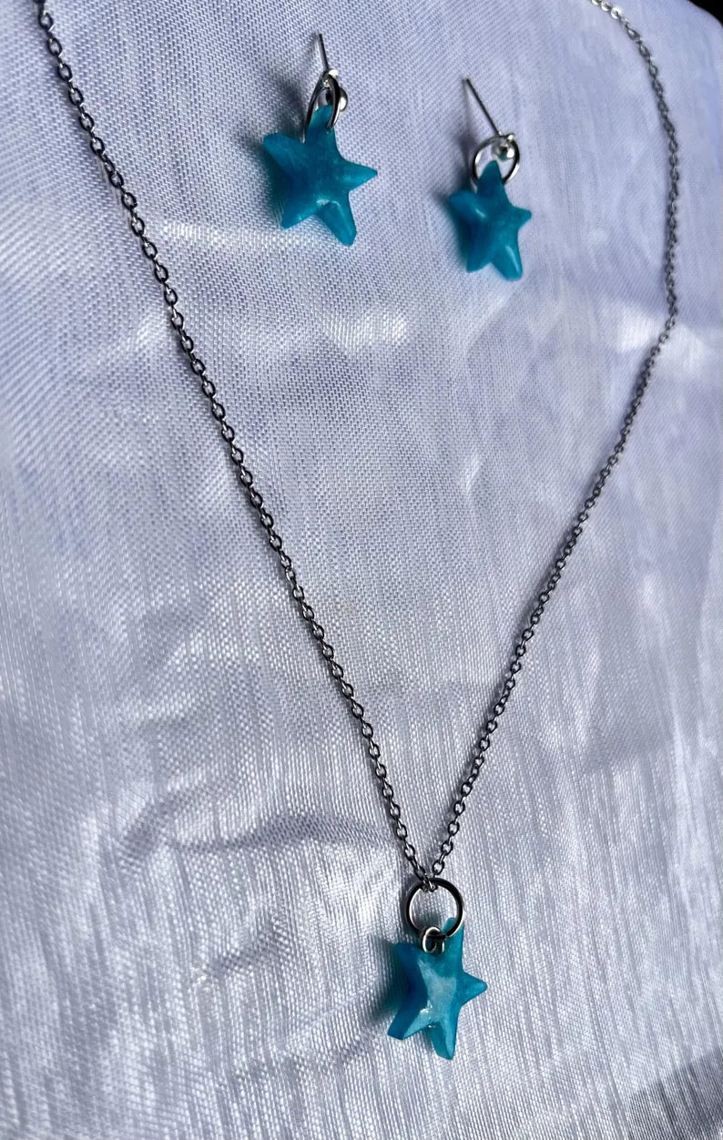 Conjuntos de pendientes y collar de estrellas de resina azules y accesorios en plateado.