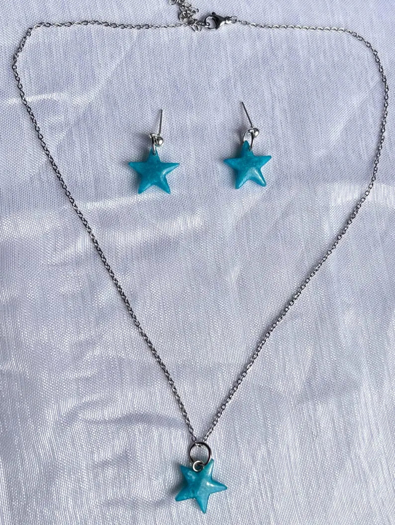 Conjuntos de pendientes y collar de estrellas de resina azules y accesorios en plateado.